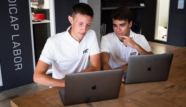 photo showing two IT employees having a meeting in front of their computers