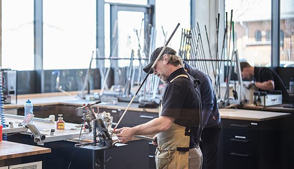 workshop employee bending an iron golf club to the right loft and lie angles