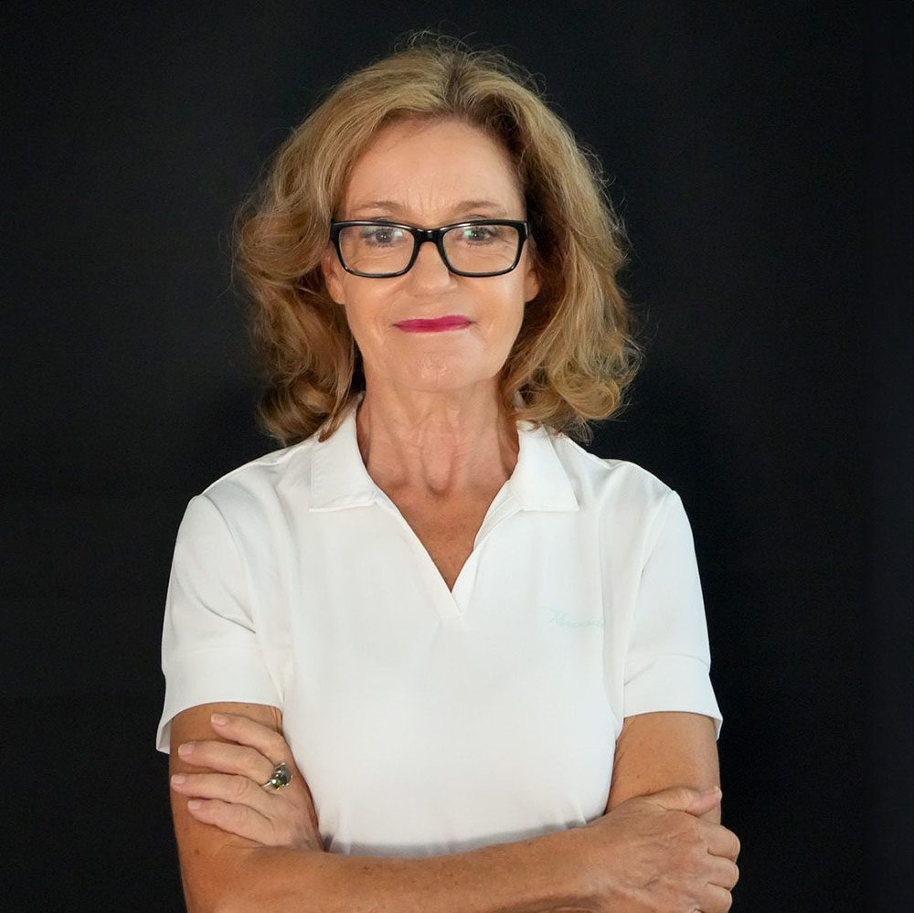 photo displaying a woman wearing a white polo smiling into the camera