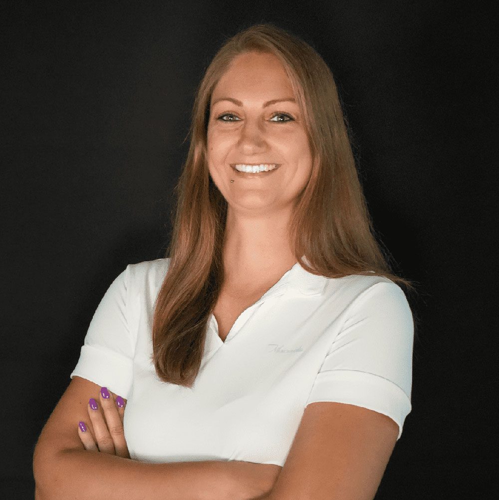 photo displaying a woman wearing a white polo smiling into the camera
