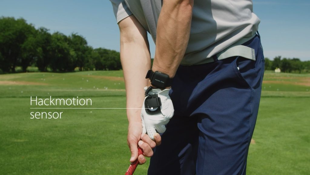 Image displaying a male golfer wearing the Hackmotion sensor in black on a golf course.